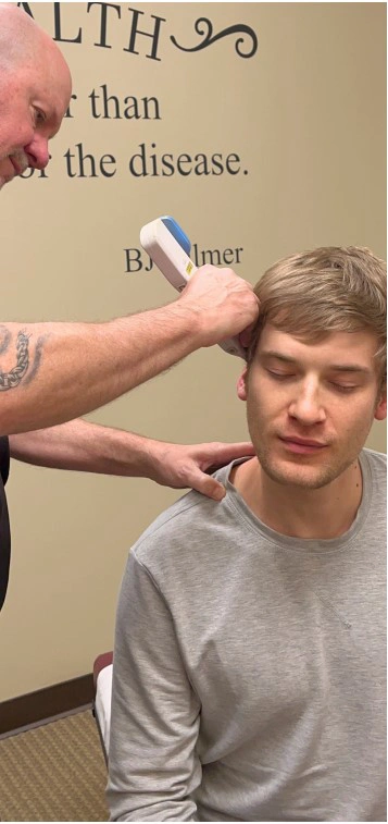 Chiropractor Parker CO Scott Godsey Using Device On Patients Head